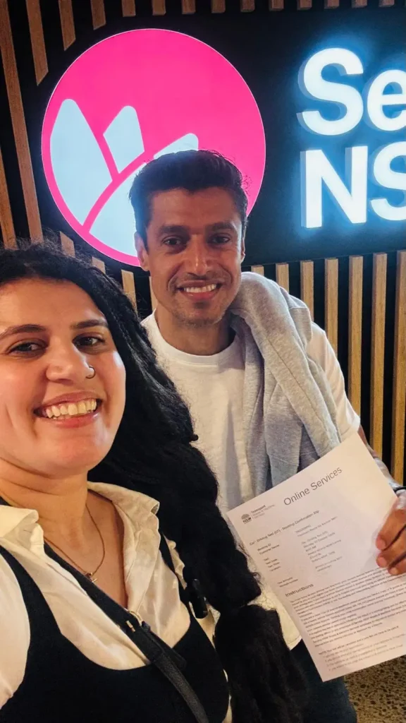 Juliane Leite com um cliente segurando documentos no Service NSW