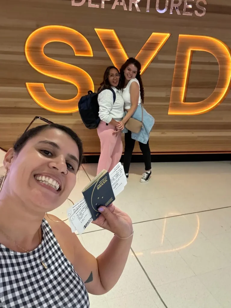 Juliane Leite com uma cliente e o passaporte no aeroporto de Sydney